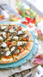 This spinach and feta pizza is a vegetarian option that combines the flavors of spinach, feta cheese, and onions with dried tomatoes.