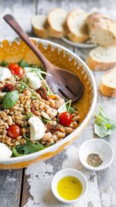 This Mediterranean farro salad is a flavorful dish that combines farro with cannellini beans, mozzarella, arugula, and sun-dried tomatoes.
